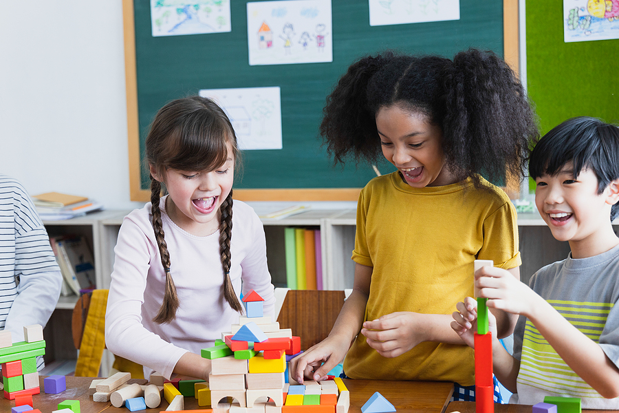 group of Diversity of school students playing wooden blocks in classroom. Elementary school children enjoy learning together. Learn to work as a team. Back to school concept